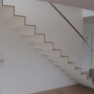 Esempio di una grande scala a rampa dritta minimalista con pedata in legno verniciato, alzata in legno verniciato e parapetto in metallo