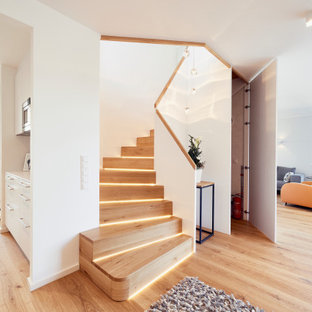 Esempio di una piccola scala curva design con pedata in legno, alzata in legno e parapetto in legno