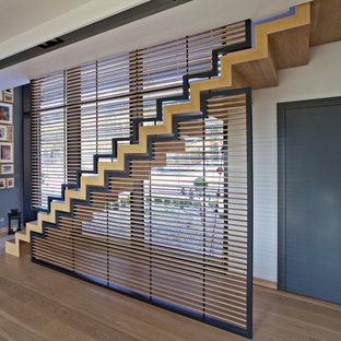 Idée de décoration pour un grand escalier droit vintage avec des marches en bois et des contremarches en bois.