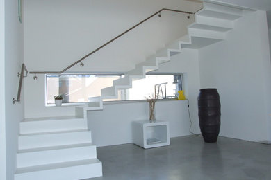 Ejemplo de escalera curva contemporánea de tamaño medio con barandilla de metal