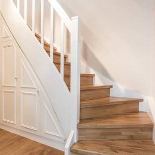 Esempio di una scala curva nordica di medie dimensioni con pedata in legno e alzata in legno
