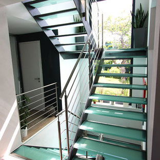 Foto di un'ampia scala a "U" contemporanea con pedata in vetro e nessuna alzata