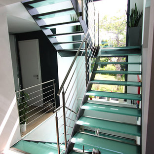 Immagine di un'ampia scala a "U" design con pedata in vetro e nessuna alzata