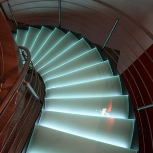 Esempio di una grande scala curva design con pedata in vetro e nessuna alzata