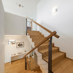 Mittelgroße Moderne Holztreppe in U-Form mit Holz-Setzstufen und Holzgeländer in Köln