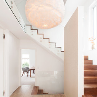 Moderne Holztreppe in U-Form mit Holz-Setzstufen und Glasgeländer in München