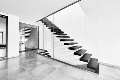 Imagen de escalera recta urbana grande con escalones de madera y barandilla de vidrio