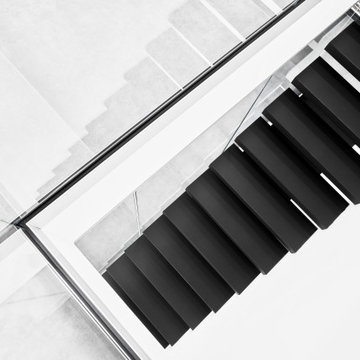 Kragarmtreppe in matt schwarz mit Weißglas