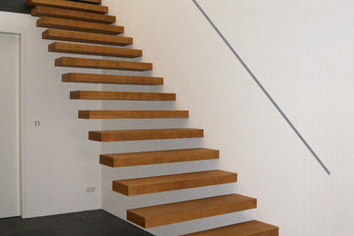 Gerade, Mittelgroße Moderne Treppe mit gebeizten Holz-Treppenstufen und offenen Setzstufen in Dortmund