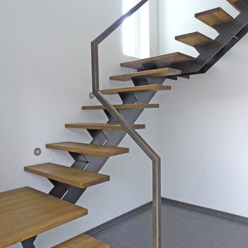 Mittelholmtreppe aus paniertem Stahl und Stufen aus Eiche