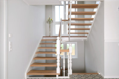 Diseño de escalera curva campestre grande con escalones de madera y barandilla de madera
