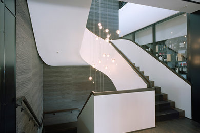 Diseño de escalera de caracol contemporánea con escalones de madera, contrahuellas de madera y barandilla de madera