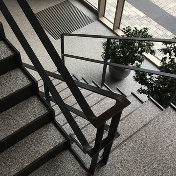 Stahltreppe zum Foyer. Belag: Natursteinteppich