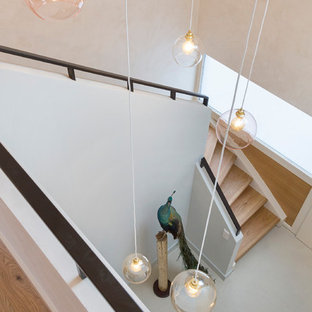 Réalisation d'un escalier courbe nordique de taille moyenne avec des marches en bois, des contremarches en bois et un garde-corps en métal.