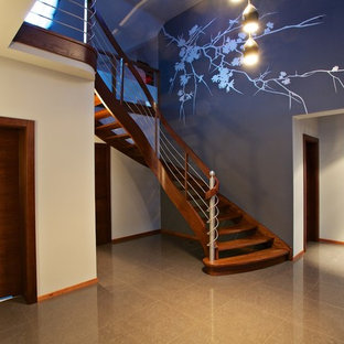 Immagine di una grande scala curva classica con pedata in legno e nessuna alzata
