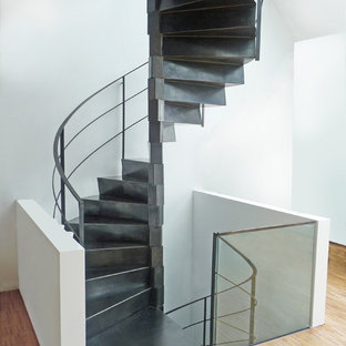 Foto di una grande scala curva contemporanea con pedata in metallo, alzata in metallo e parapetto in metallo