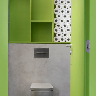 Imagen de aseo industrial con sanitario de pared, paredes verdes y suelo gris