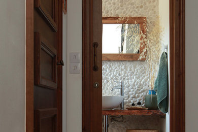 На фото: туалет в средиземноморском стиле с белыми стенами, полом из керамической плитки и серым полом