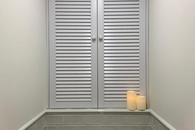 Foto de aseo actual pequeño con armarios con puertas mallorquinas, puertas de armario grises, baldosas y/o azulejos verdes y paredes blancas
