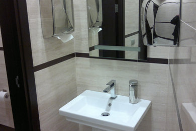 モスクワにあるコンテンポラリースタイルのおしゃれなトイレ・洗面所 (一体型トイレ	、ベージュのタイル、セラミックタイル、ベージュの壁、磁器タイルの床、ペデスタルシンク、ベージュの床) の写真