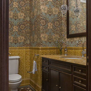 Foto di un bagno di servizio vittoriano con ante con riquadro incassato, ante in legno bruno, WC a due pezzi, pareti multicolore, pavimento multicolore e top giallo