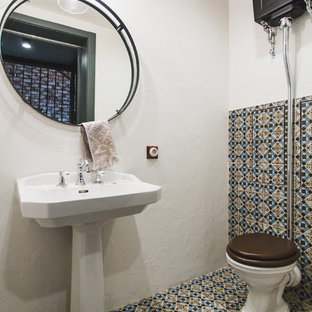 Inspiration pour un WC et toilettes méditerranéen avec un WC séparé, un carrelage multicolore, un mur blanc, un lavabo de ferme et un sol multicolore.