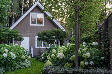 На фото: летний участок и сад среднего размера на боковом дворе в классическом стиле с полуденной тенью и садовой дорожкой или калиткой с