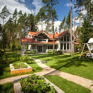 На фото: участок и сад на переднем дворе в стиле неоклассика (современная классика) с детским городком с