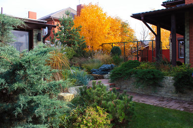 Réalisation d'un jardin design l'automne et de taille moyenne avec un mur de soutènement, une exposition partiellement ombragée et des pavés en béton.