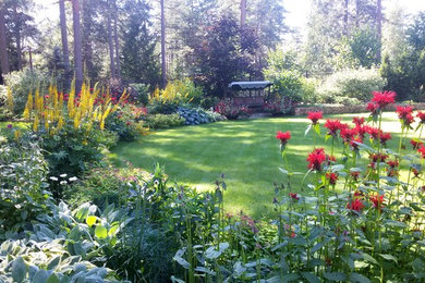 Diseño de jardín tradicional de tamaño medio en verano en patio delantero con exposición parcial al sol y adoquines de hormigón