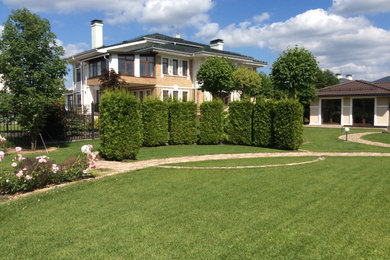 Diseño de jardín clásico de tamaño medio en verano en patio trasero con exposición total al sol