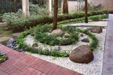 Bild på en funkis formell trädgård på sommaren, med marksten i betong