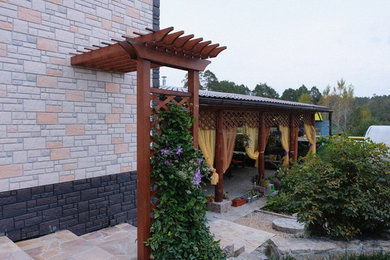Cette image montre un petit jardin sur cour l'automne avec un mur de soutènement, une exposition partiellement ombragée et des pavés en pierre naturelle.