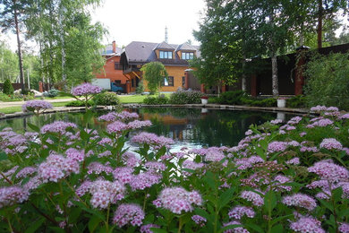 Ejemplo de jardín contemporáneo grande en verano en patio con estanque y exposición parcial al sol