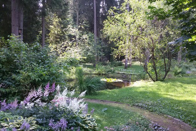 Imagen de jardín tradicional renovado grande en verano en patio delantero con estanque, exposición parcial al sol y gravilla