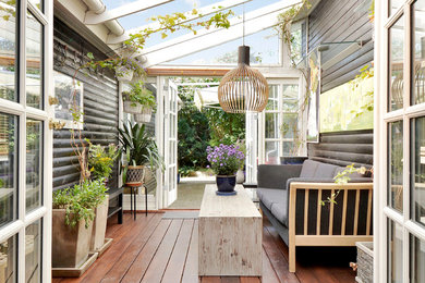 Immagine di una veranda scandinava di medie dimensioni con parquet scuro e soffitto in vetro