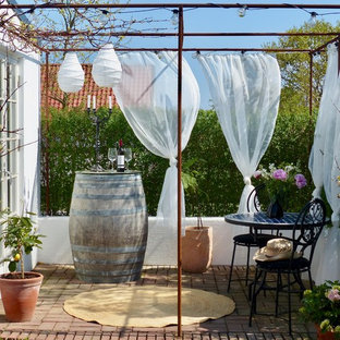 Idéer för att renovera en liten medelhavsstil uteplats, med marksten i tegel, en pergola och utekrukor