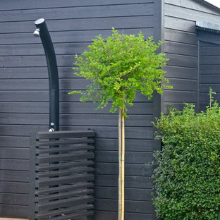 Idee per un patio o portico di medie dimensioni e dietro casa con un giardino in vaso, graniglia di granito e un parasole