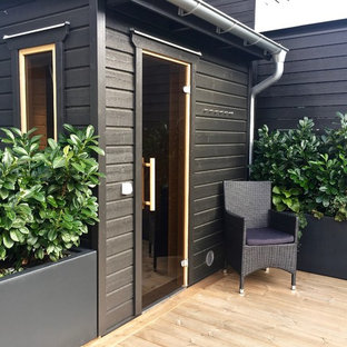 Ispirazione per un patio o portico nordico di medie dimensioni e dietro casa con un giardino in vaso, graniglia di granito e un parasole