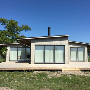 Ispirazione per un patio o portico scandinavo con pedane e un tetto a sbalzo