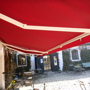 Immagine di un patio o portico scandinavo con un parasole