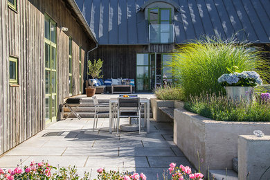 Idéer för mellanstora minimalistiska uteplatser på baksidan av huset, med naturstensplattor