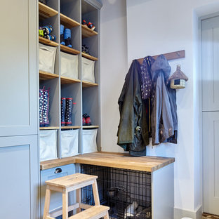 Inspiration pour une buanderie parallèle design multi-usage et de taille moyenne avec un évier de ferme, un placard à porte shaker, des portes de placard grises, un plan de travail en marbre, un mur gris, un sol en carrelage de porcelaine et des machines côte à côte.