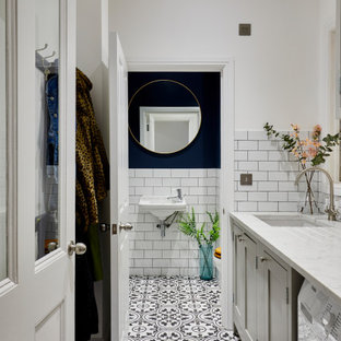 Design ideas for a classic single-wall utility room in London with white walls, a side by side washer and dryer and white worktops.