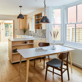 Réalisation d'une buanderie minimaliste multi-usage avec un placard sans porte, des portes de placard en bois clair, un plan de travail en surface solide, un sol en bois brun, des machines dissimulées, un sol marron et un plan de travail jaune.