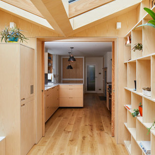 Inspiration för moderna gult grovkök, med öppna hyllor, skåp i ljust trä, bänkskiva i koppar, mellanmörkt trägolv, tvättmaskin och torktumlare byggt in i ett skåp och brunt golv