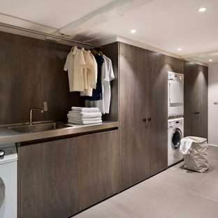 Ispirazione per una sala lavanderia minimal con lavello integrato, lavatrice e asciugatrice a colonna, top in acciaio inossidabile e top grigio