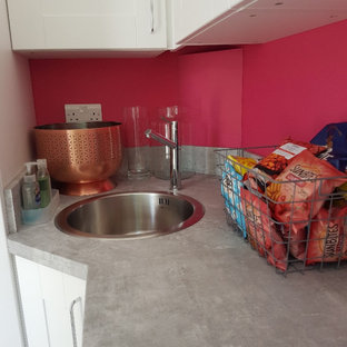 Inspiration för små moderna grått tvättstugor, med en allbänk, skåp i shakerstil, vita skåp, laminatbänkskiva, grått stänkskydd, rosa väggar, linoleumgolv och svart golv
