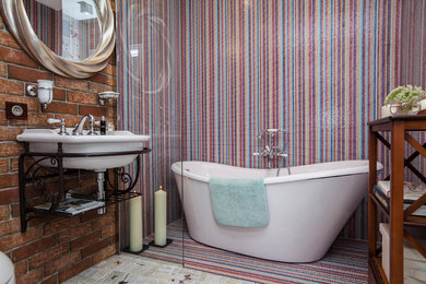 Ejemplo de cuarto de baño actual con bañera exenta, paredes multicolor y lavabo suspendido