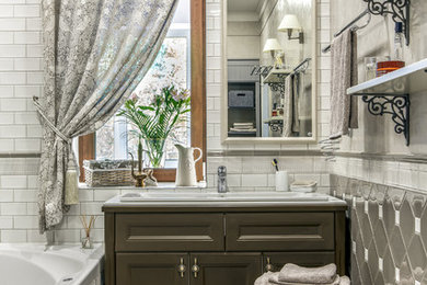 На фото: главная ванная комната среднего размера: освещение в классическом стиле с фасадами с утопленной филенкой, коричневыми фасадами, белой плиткой, серой плиткой, накладной раковиной и бежевым полом с